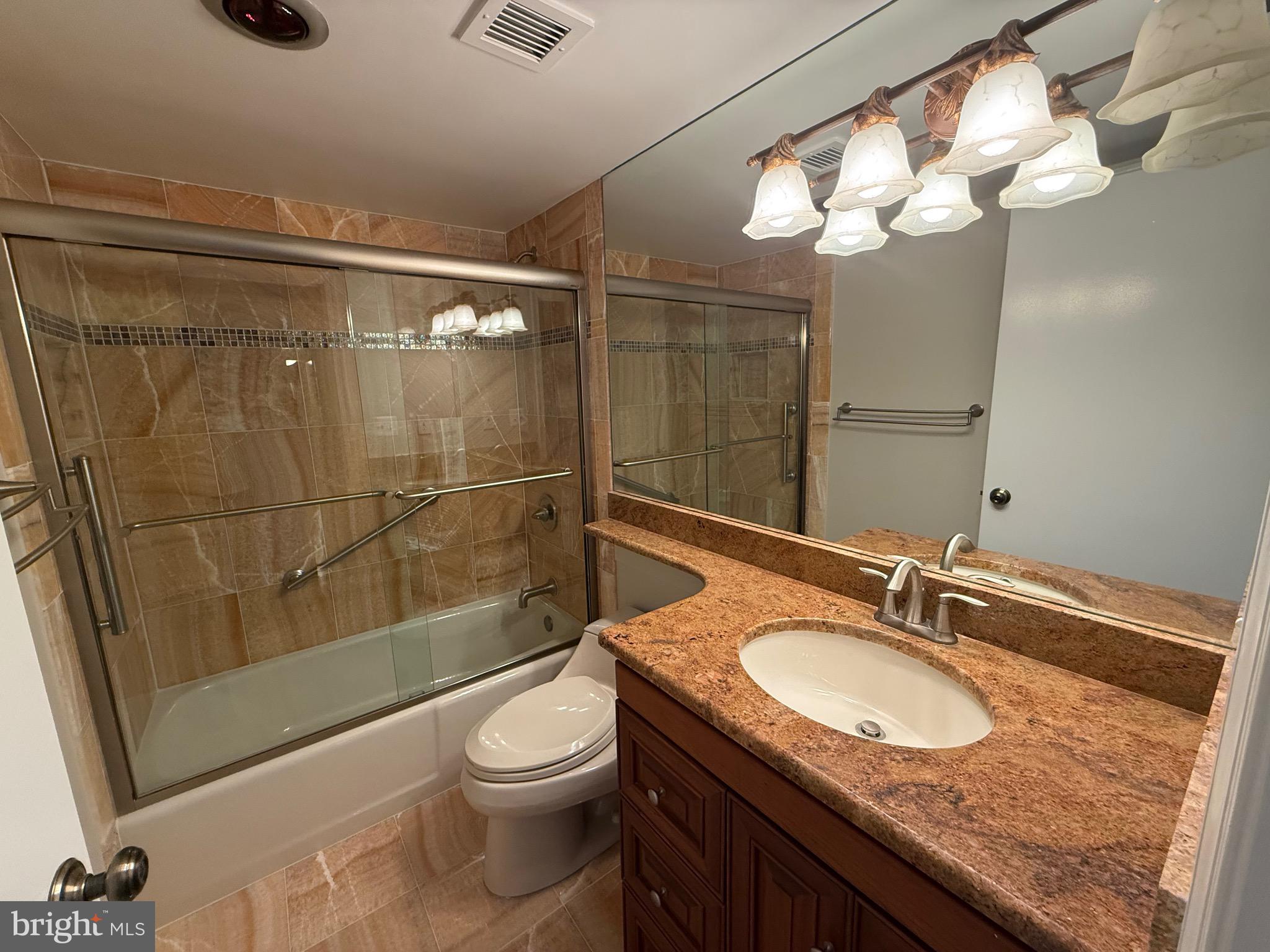 1101 South Arlington Ridge Road, Unit 214 Arlington, VA 22202 - Photo 29 of 41 a bathroom with a granite countertop sink a toilet a mirror and shower