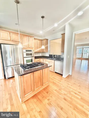 a kitchen with stainless steel appliances granite countertop a refrigerator and a stove top oven
