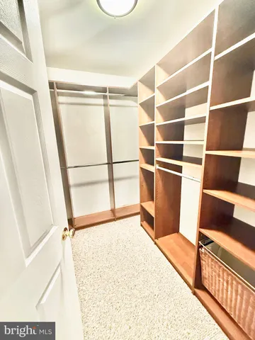 an empty room with closet and a ceiling fan