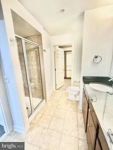 an empty room with windows and chandelier fan