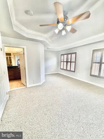an empty room with windows and ceiling fan