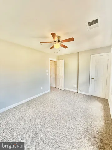 en empty room with ceiling fan and window