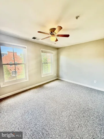 en empty room with ceiling fan and window