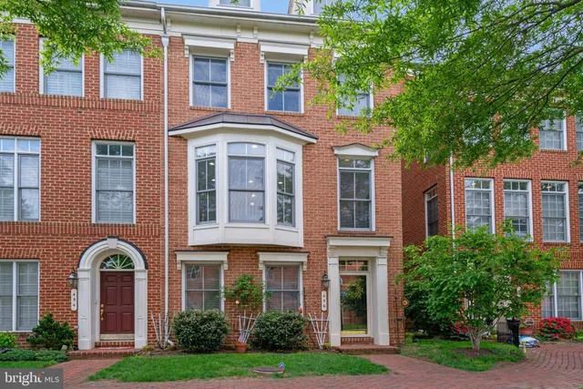 a front view of residential houses with yard and green space