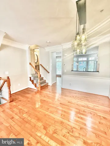 a view of an empty room with wooden floor and a floor to ceiling window