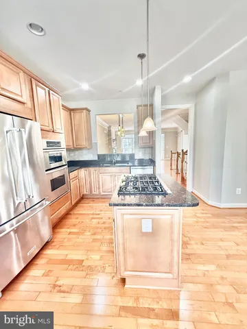 a large kitchen with kitchen island granite countertop a stove a sink and a granite counter tops