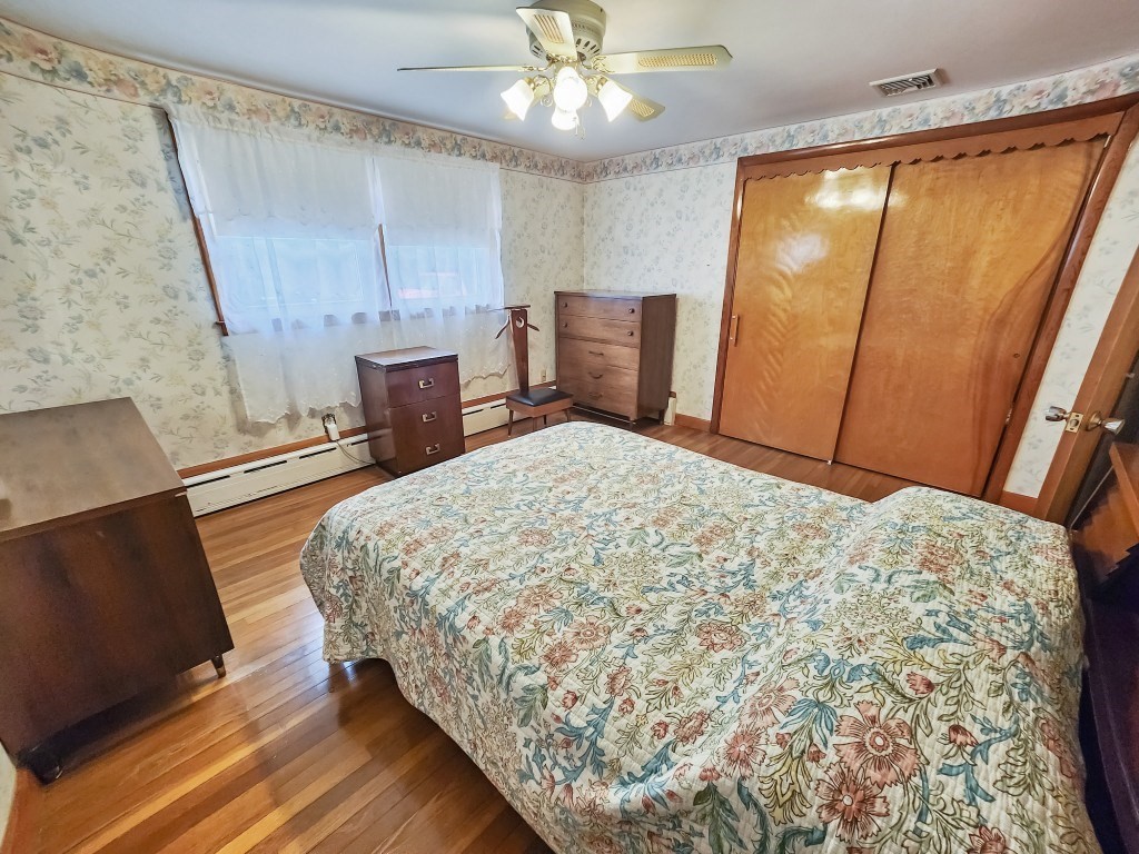 415 Chase Road Dartmouth, MA 02747 - Photo 17 of 34 a bedroom with a bed and a dresser with wooden floor