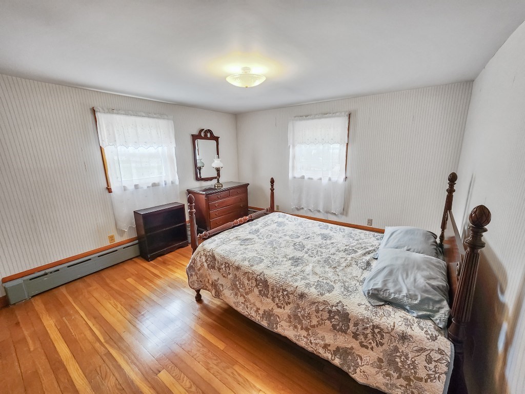 415 Chase Road Dartmouth, MA 02747 - Photo 24 of 34 a bed sitting in a bedroom next to a window with wooden floor