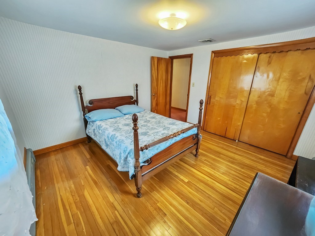 415 Chase Road Dartmouth, MA 02747 - Photo 25 of 34 a bedroom with a bed and wooden floor