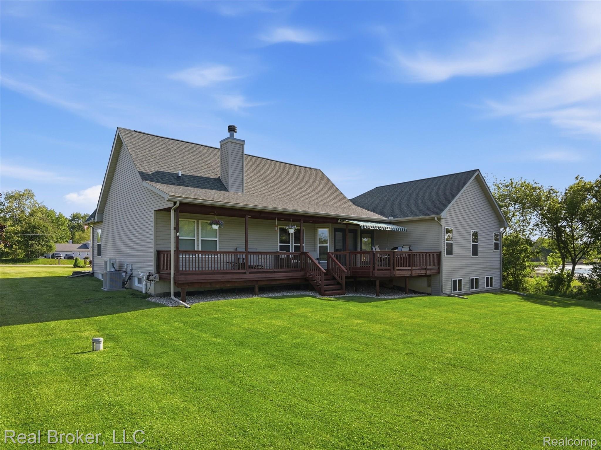 7271 West Ray Road Gaines, MI 48436 - Photo 13 of 48 Expansive green lawn with a multi-level wood deck and covered porch