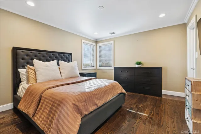 a spacious bedroom with a bed and a flat screen tv
