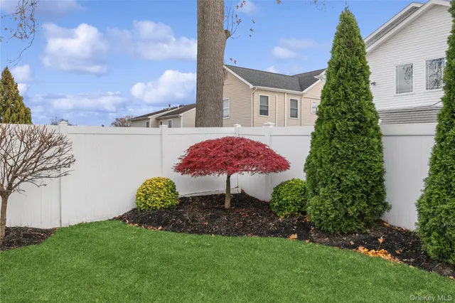 a view of a white house with a yard and table and chairs