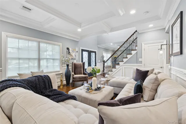 a living room with furniture large windows and wooden floor