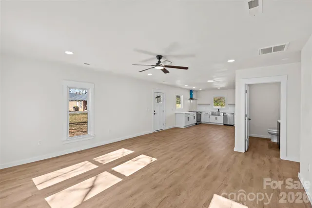 a view of a livingroom with wooden floor and a ceiling fan