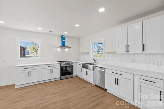 a kitchen with white cabinets and stainless steel appliances