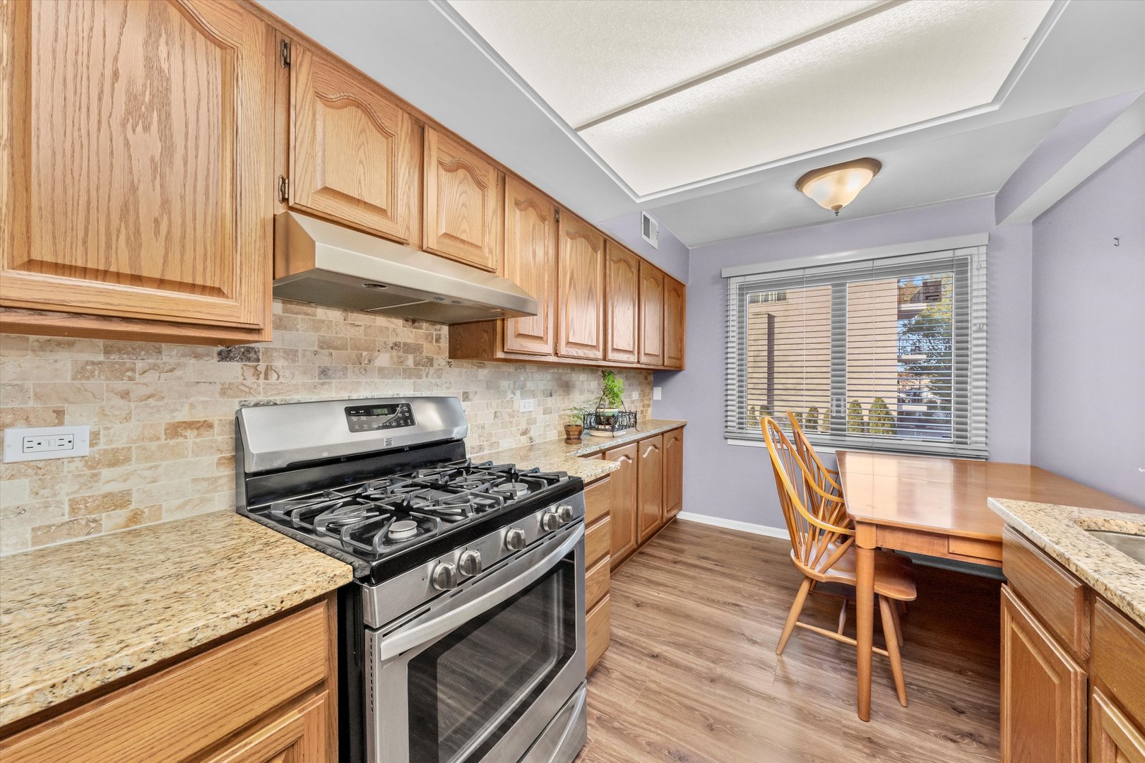 4530 West 93rd Street, Unit 1A Oak Lawn, IL 60453 - Photo 5 of 18 a kitchen with a stove a sink and wooden cabinets