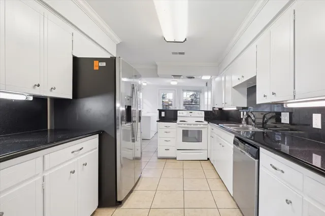 a kitchen with white cabinets and white appliances