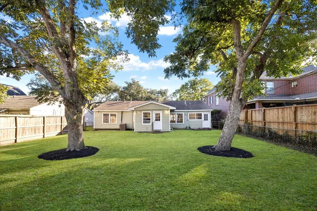 a front view of a house with a garden and trees