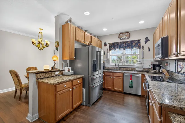 a kitchen with stainless steel appliances granite countertop a stove refrigerator sink and cabinets