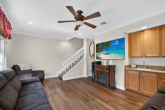 a living room with stainless steel appliances furniture and a kitchen view