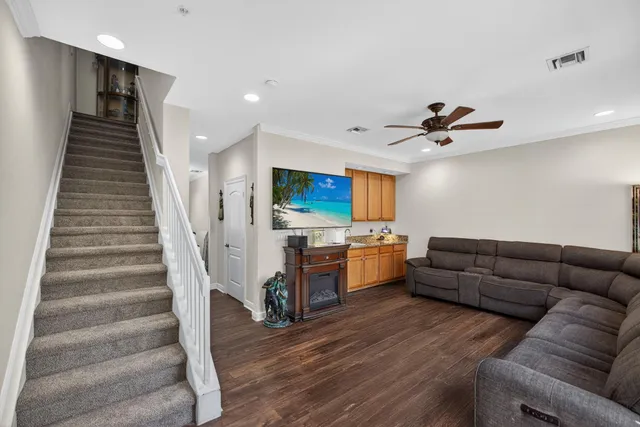 a living room with furniture kitchen view and a flat screen tv