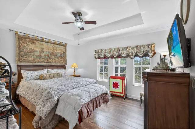 a bedroom with a bed and a flat tv screen on dresser