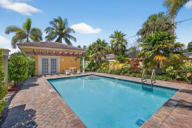 a front view of a house with a garden and a tree
