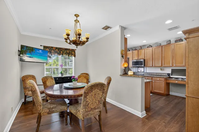 a dining room with furniture a chandelier and wooden floor