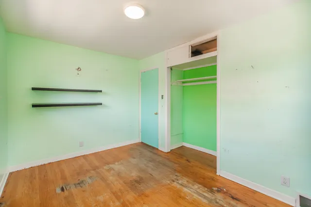 a view of a room with a wooden floor and entryway