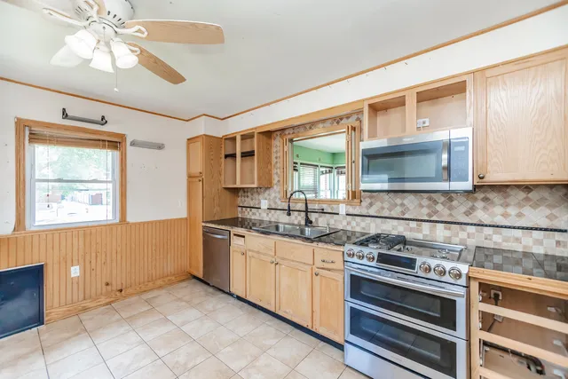 a kitchen with stainless steel appliances a stove sink and cabinets