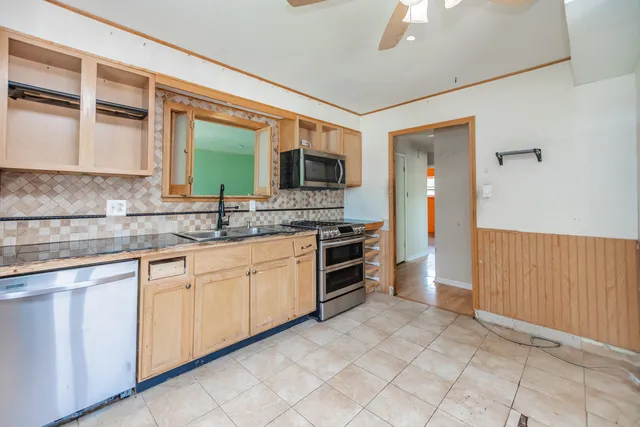 a kitchen with granite countertop a stove top oven microwave and cabinets