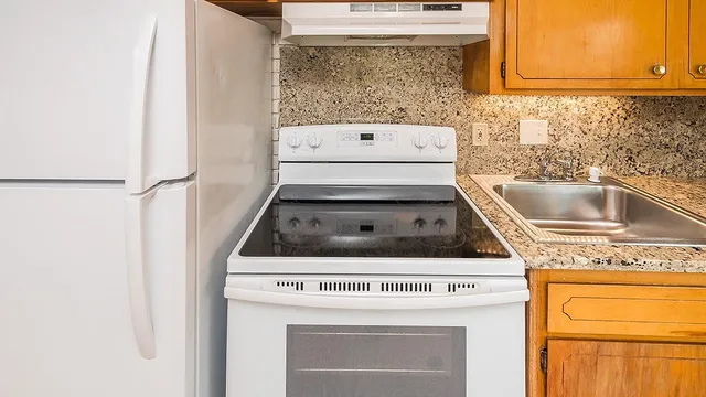 a stove top oven sitting inside of a kitchen