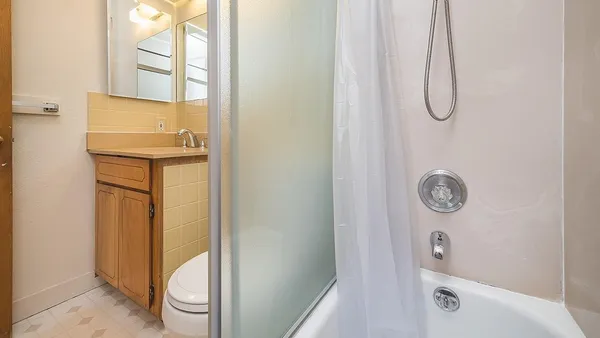 a bathroom with a granite countertop shower a toilet and a sink