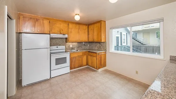 a kitchen with white cabinets and white appliances