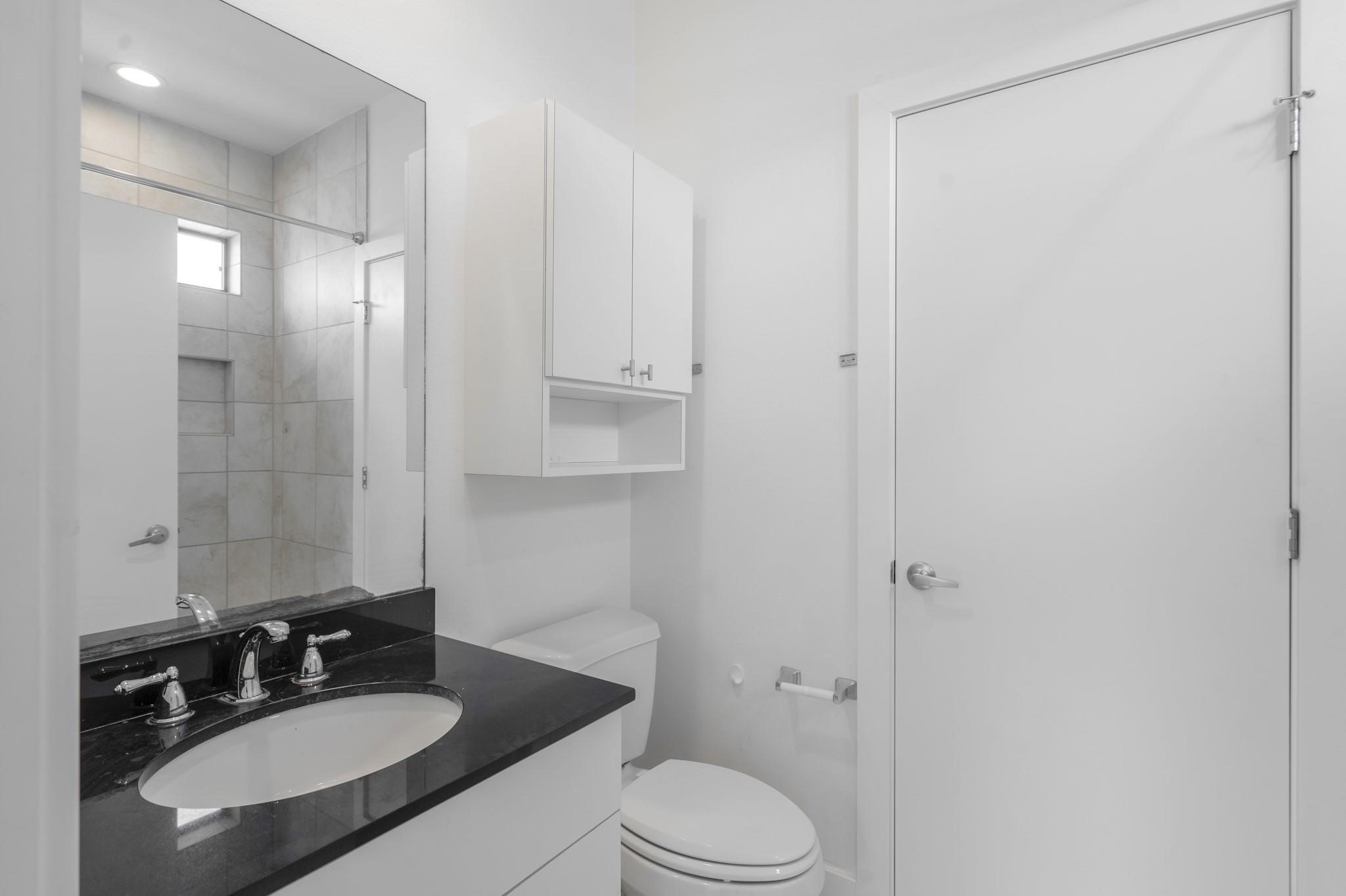 4302 Spencer Street Houston, TX 77007 - Photo 18 of 21 a bathroom with a sink toilet a mirror and shower