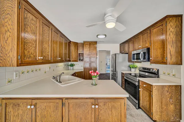 a kitchen with stainless steel appliances a sink stove refrigerator and cabinets