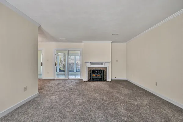 a view of an empty room with a fireplace and a window