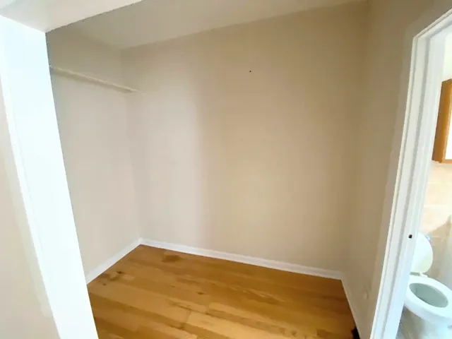 a small space with wooden floor and a window