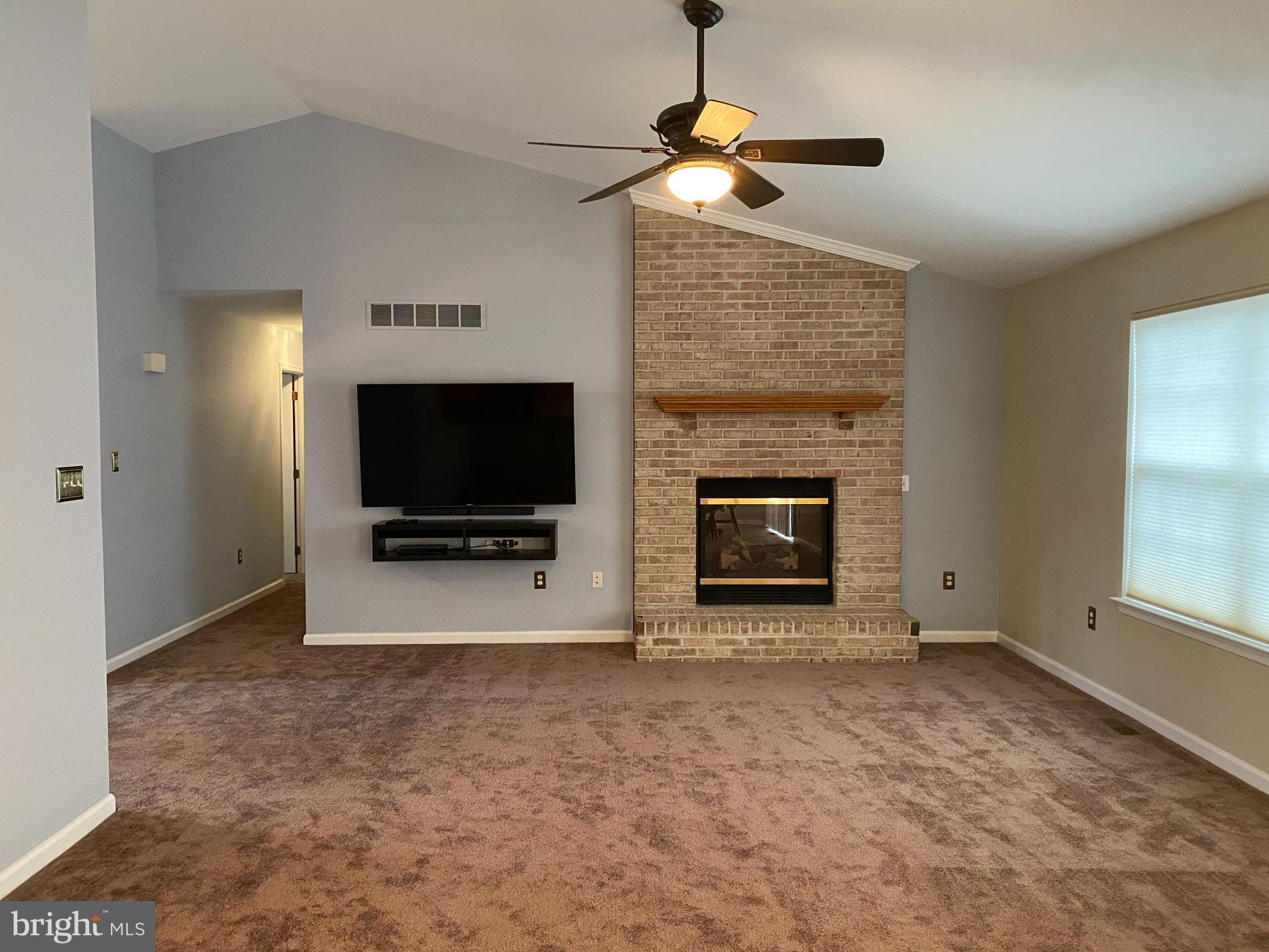 14 Mailly Drive Townsend, DE 19734 - Photo 3 of 22 an empty room with windows fireplace and a flat tv screen
