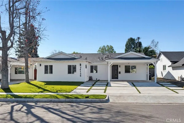 a view of a house with a big yard and large trees