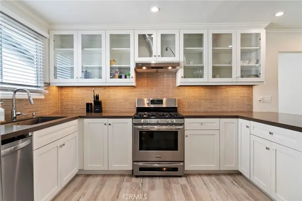 a kitchen with stainless steel appliances granite countertop a stove and white cabinets
