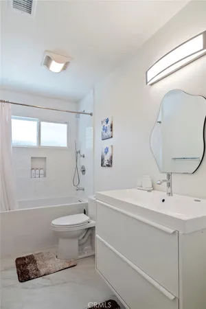 a bathroom with a sink a toilet and a mirror