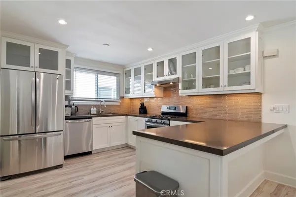 a kitchen with stainless steel appliances a stove a sink a refrigerator and cabinets