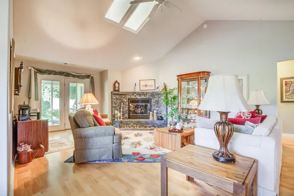 a living room with fireplace furniture and a large window