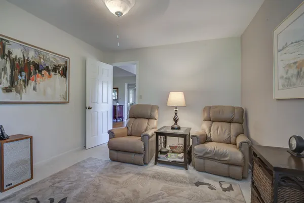 a living room with furniture and a painting on the wall
