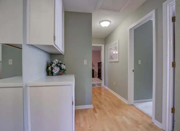 a view of a hallway to room with wooden floor and staircase