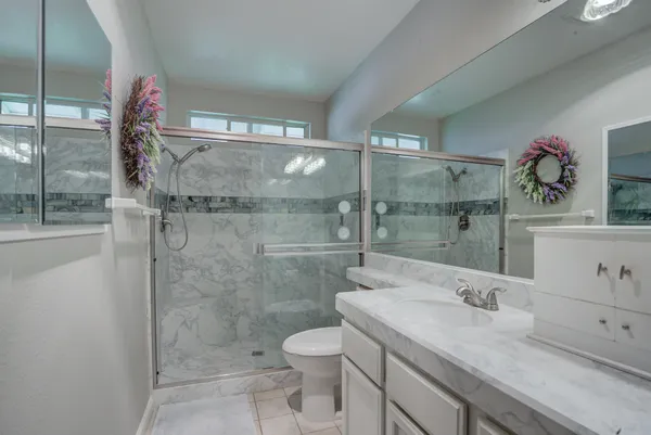 a bathroom with a granite countertop sink toilet and shower