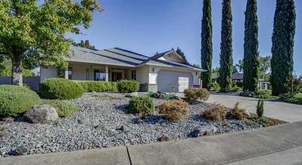 a view of a house with a yard and large tree