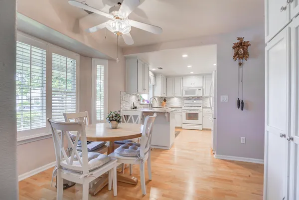 a view of a dining room and livingroom with furniture wooden floor a chandelier