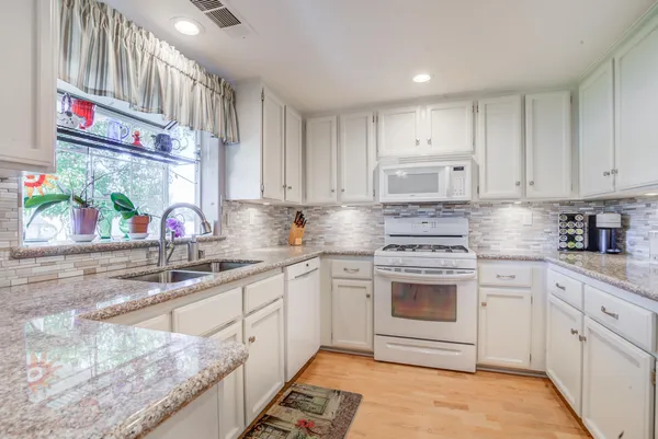 a kitchen with stainless steel appliances granite countertop a sink stove and cabinets